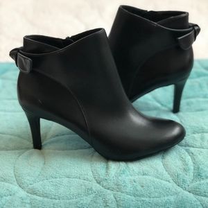 Black ankle boots with bow on back.